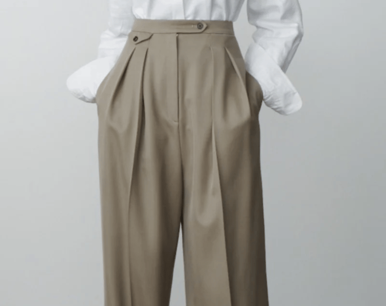 a woman with high-waisted pants and a white shirt