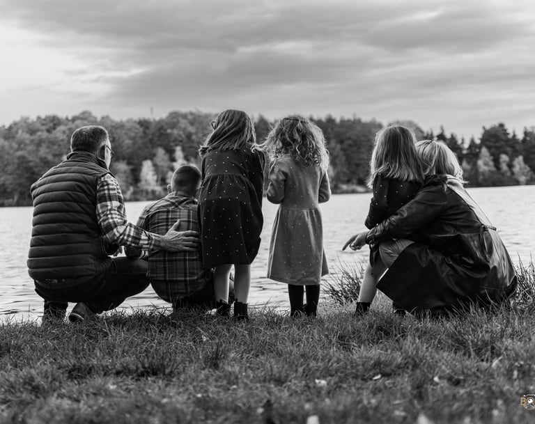 a family of four children sitting on the grass
