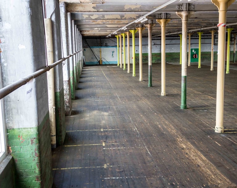 Image of the left side of the Main room, showing the coloured poles, wooden floor & textured walls.