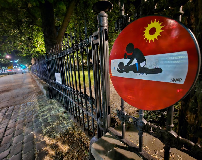 Street art sur panneau de signalisation représentant un couple sur un sens interdit