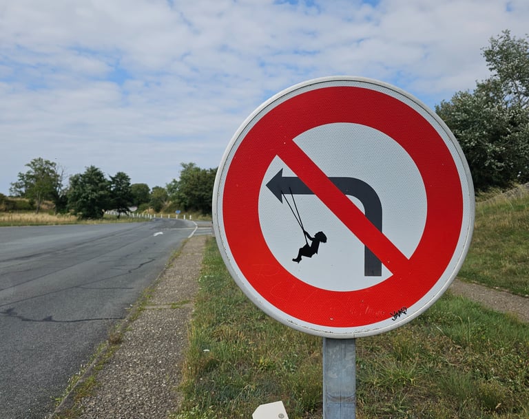 Street art sur panneau de signalisation représentant un fille sur une balançoire