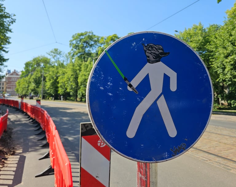 a street sign with a star wars lightsabed sticker on it