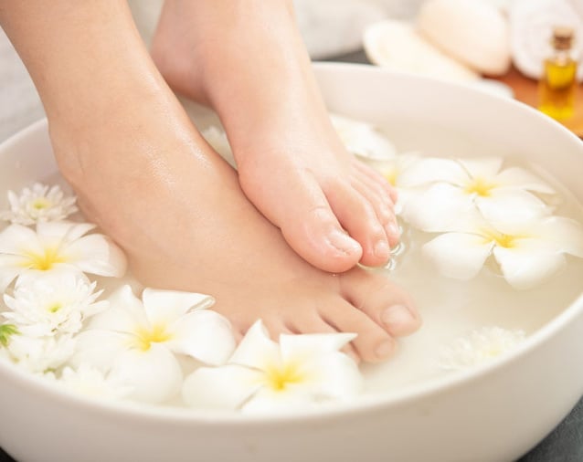 Relaxerend voetenbad met bloemen en natuurlijke oliën bij Medisch Pedicure Grote Berg.