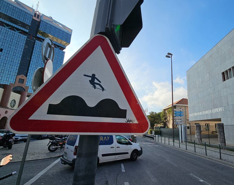 Street art sur panneau de signalisation représentant un skateur sur un dos d'ane à Lisbonne