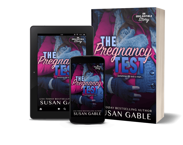 A table, a cell phone, and a paperback version of the book The Pregnancy Test by Susan Gable. 
