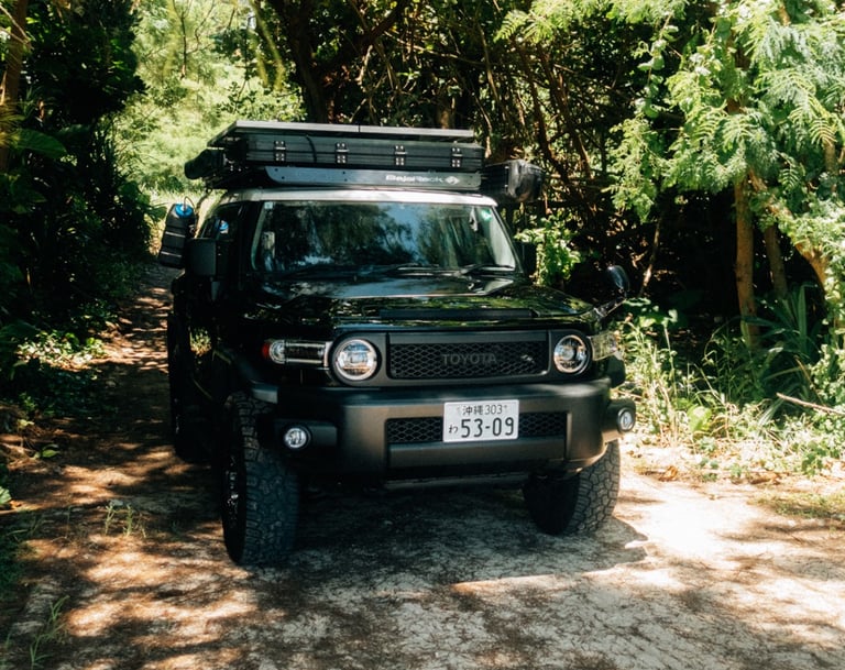 Toyota FJ Cruiser parked on a sandy trail surrounded by lush greenery in Okinawa. | Evertrail Okinawa