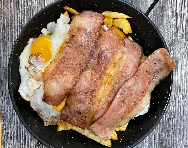 huevos rotos con patatas caseras y beicon frito