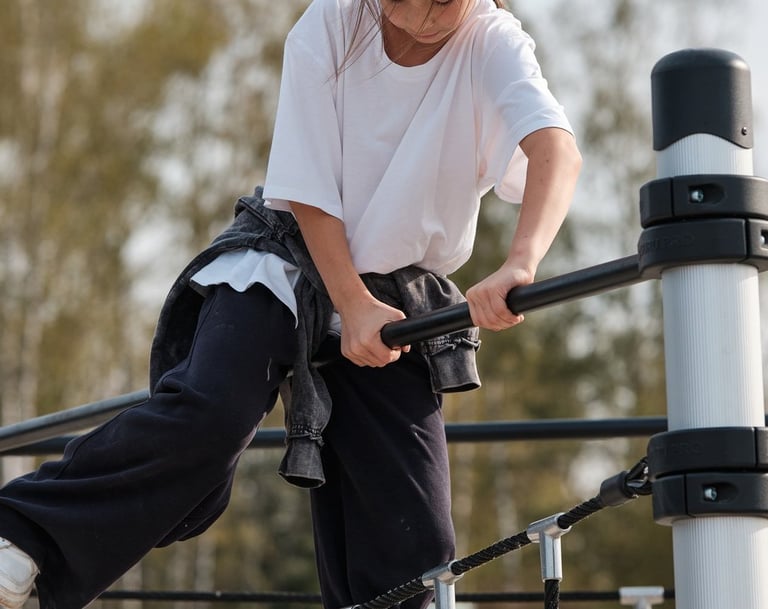 Fille grimpant sur une structure Kenguru Pro Kids Active Play en extérieur.
