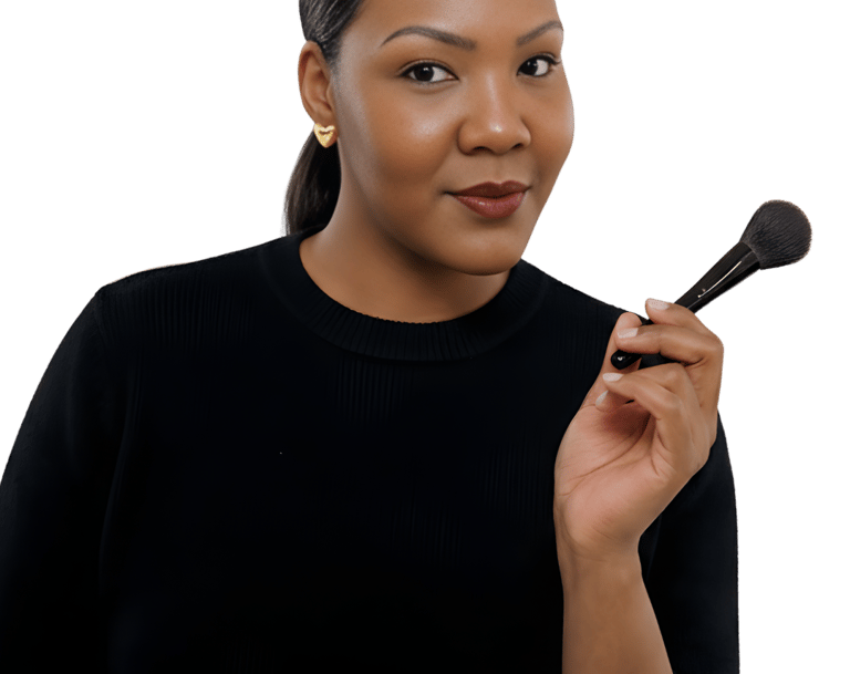 Professional makeup artist holding a blending brush against a black background.