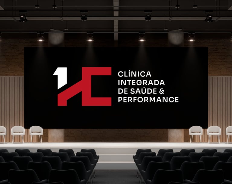 Auditório moderno com telão exibindo o logo HC e o texto “Clínica Integrada de Saúde & Performance”.