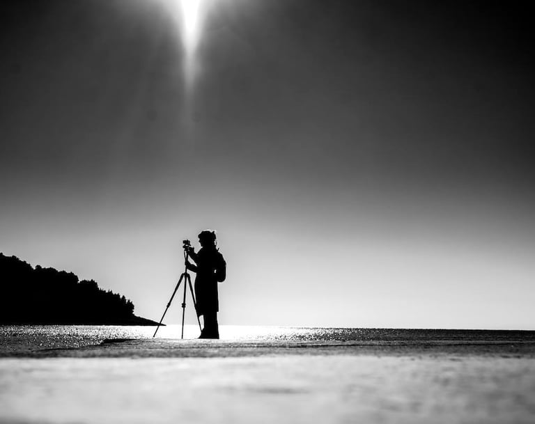 Tina Bikic holding a camera, black and white artistic portrait.