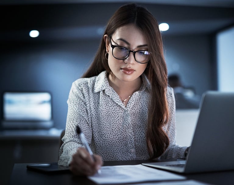 Professional woman with glasses working late on a laptop