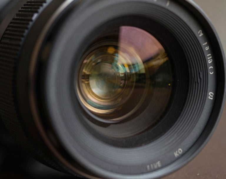 An extreme close up of a lens reflecting charcoal gray and antique gold light, cinematic depth of field, sophisticated and artistic style.