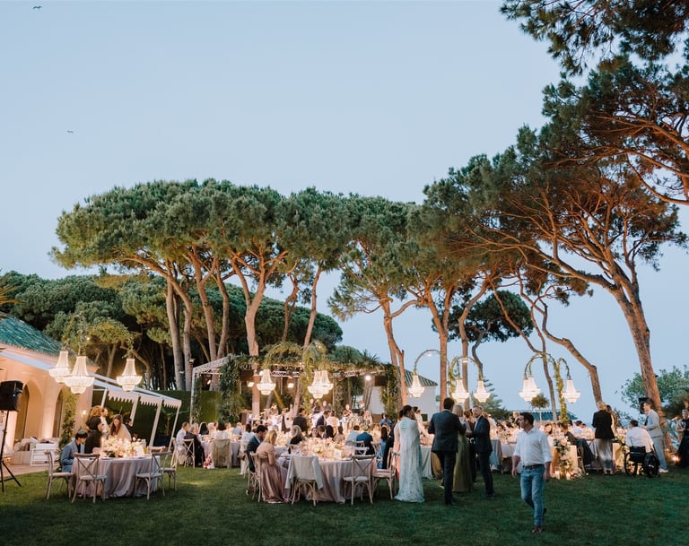 Evening wedding reception at Villa El Rincon with chandeliers and garden dining