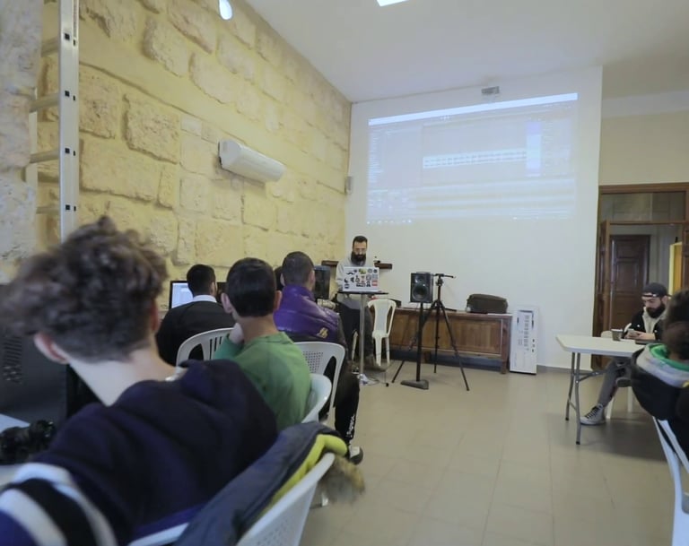 a group of people sitting at tables in a room in a workshop given by beatlalipos in lebanon