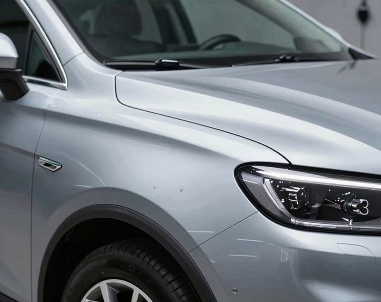 The 'After' shot: The same car panel from the previous image, now perfectly smooth with no trace of the dent. The metallic paint sparkles under studio lights, reflecting a clean workshop. Professional and high-quality finish.