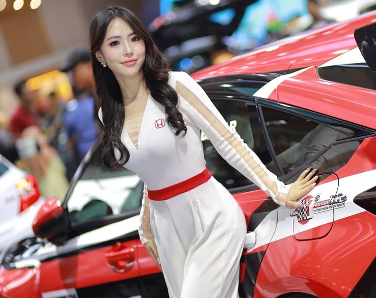 a woman in a white dress standing next to a red car