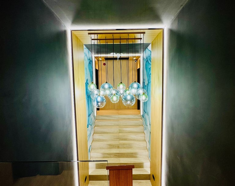 Holul principal elegant al Pensiunii MAPAMONT din Văliug, luminat de un candelabru masiv.