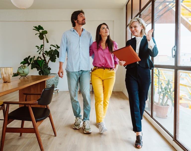 a man and woman walking through a room with a laptop