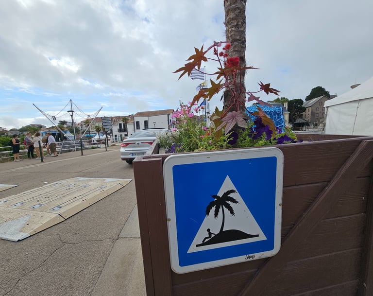 Street art sur panneau de signalisation représentant une ile déserte sur un dos d'âne.