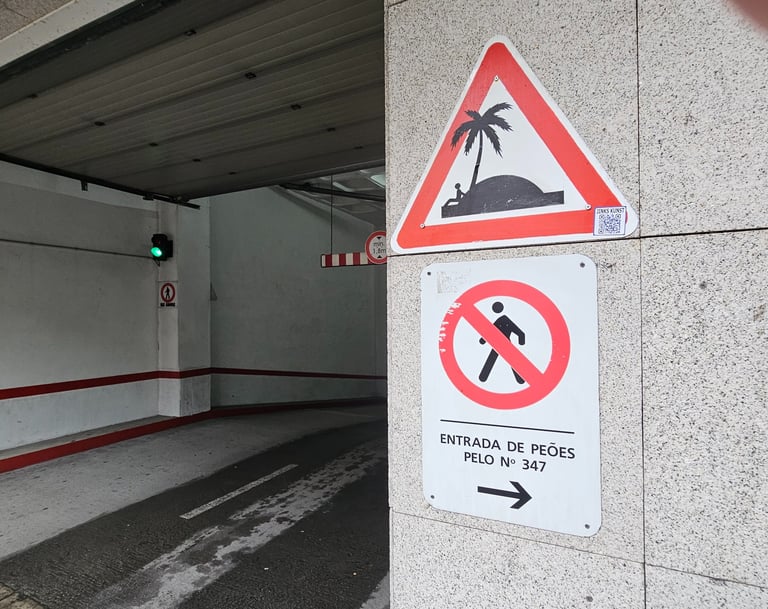Street art sur panneau de signalisation représentant une ile déserte sur un dos d'âne.