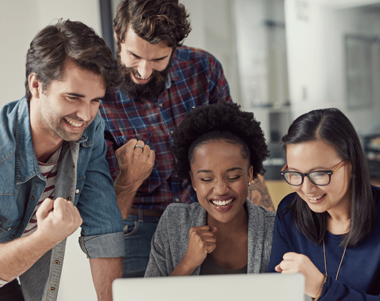 A team celebrating success looking at a computer screen at their achievement