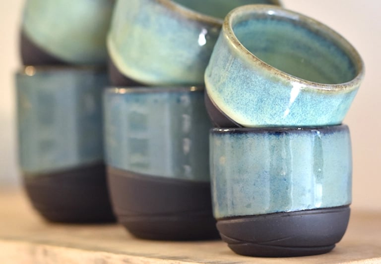 Handgemaakte espressokopjes koffiekopjes en theemokken van zwarte klei met groene en sage glazuur
