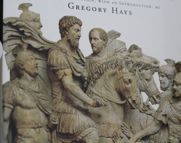 Close-up of the Meditations book cover by Marcus Aurelius featuring Roman relief sculptures of soldiers and horses.
