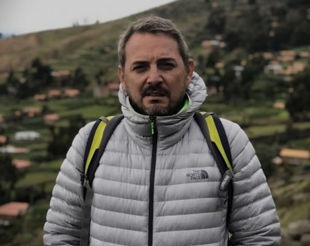 a man in a grey jacket and a backpacker