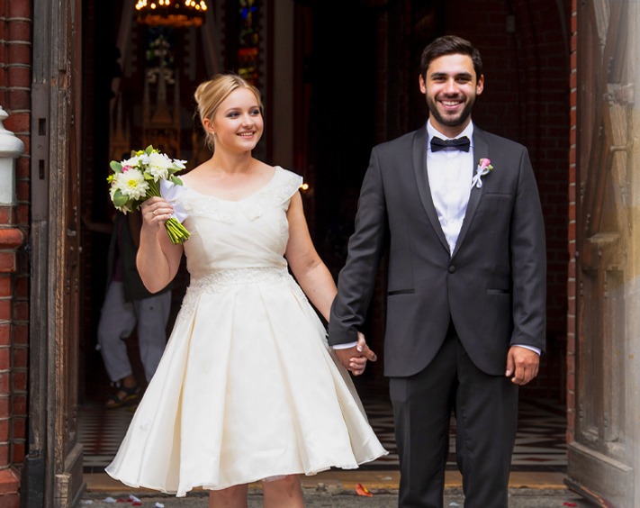 vestuviu fotosesija jaunavedziai iseina is palangos baznycios