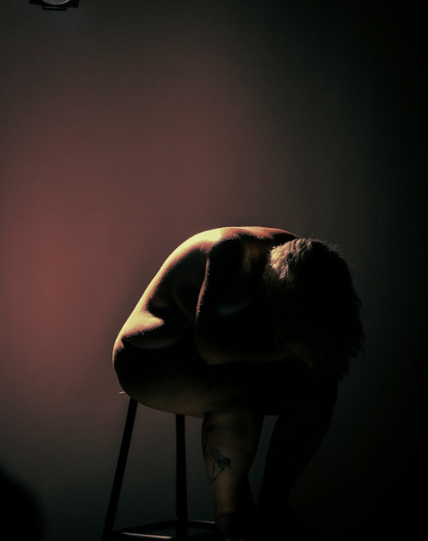 a man sitting on a chair in a dark room