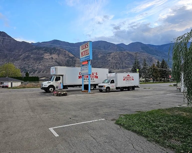 Canada’s Most Wanted Movers fleet parked at Elks Motel with mountain views during a long-distance move in BC.