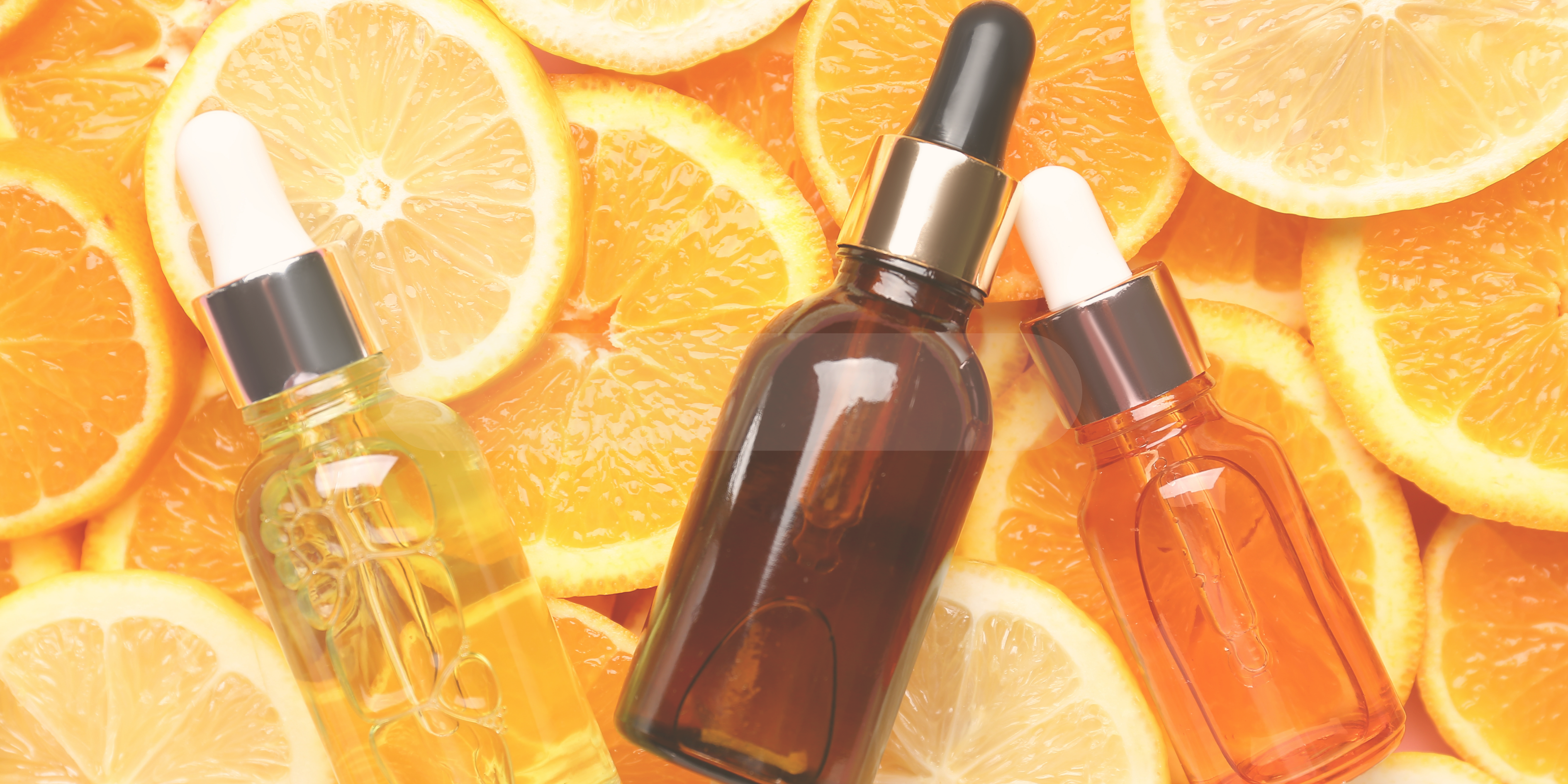 Frasco de sérum de vitamina C sobre a fruta laranja, representando cuidados com a pele e brilho na