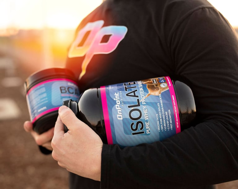 A person with an OP logo black shirt holding two bottles of supplements: One protein and one BCAA