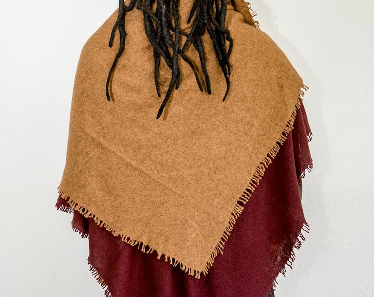Man with dreadlocks wearing two-tone yak wolle shawl in brown and burgundy, styled from the back.