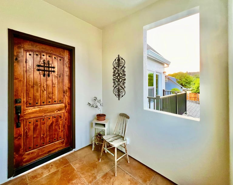 Welcoming entryway with a warm stained wood door and seating area.