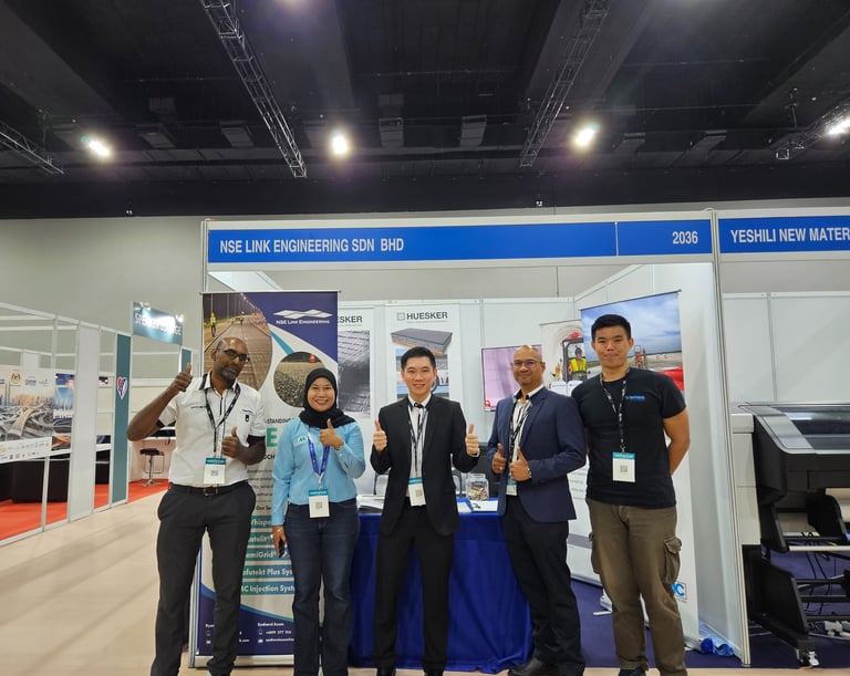NSE Link Engineering team posing at their professional trade show booth during a construction industry exhibition.
