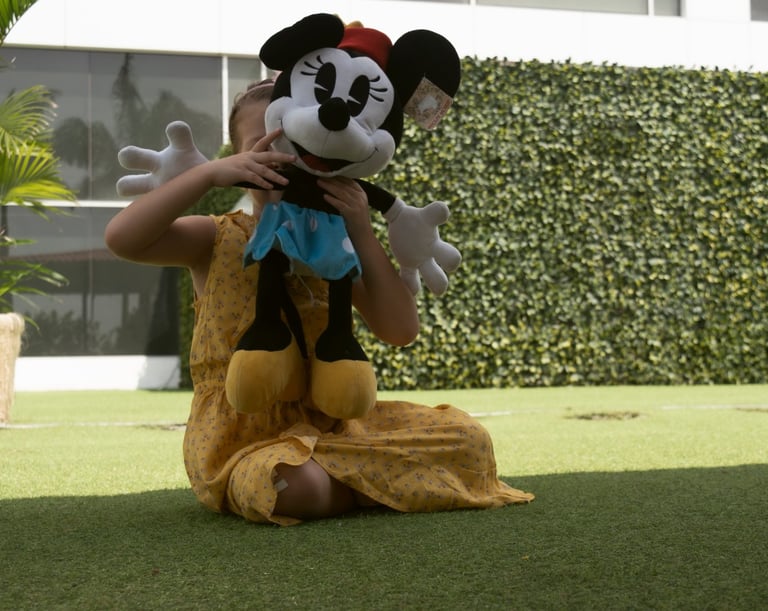 Niña jugando con su peluche de michey mouse