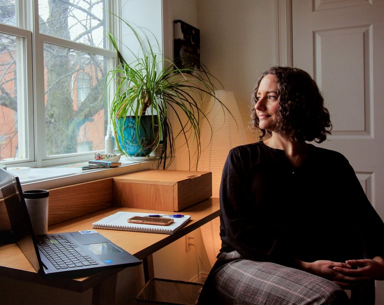 Angela Amirault, psychedelic therapist, sits in her office looking out the window