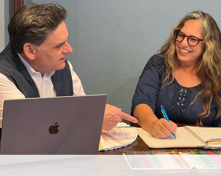 a man and woman sitting at a table with a laptop