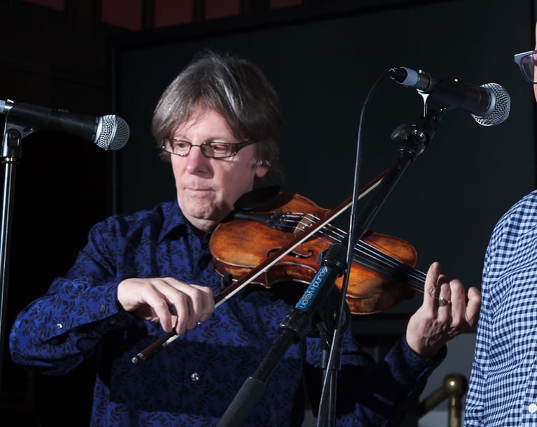 fiddler and singer performing with microphones