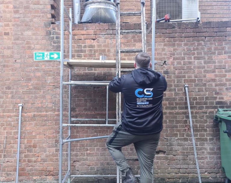 a man in cs cleaning and ducting company workwear fixing ducting