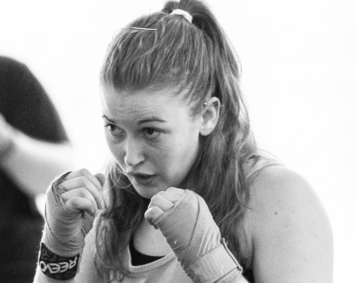 Jessica wearing handwraps with her hands up in a fighting position.