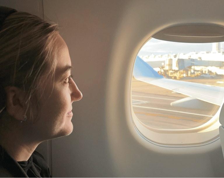 A lady looking out an airplane window
