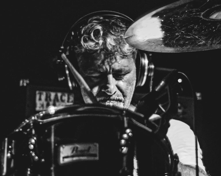 Batteur capturé en pleine action sur scène à Pau, en noir et blanc par Thomas Bordas.
