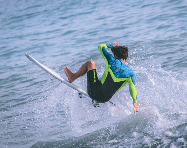 a man in a wetsuit surfing on a surfboard