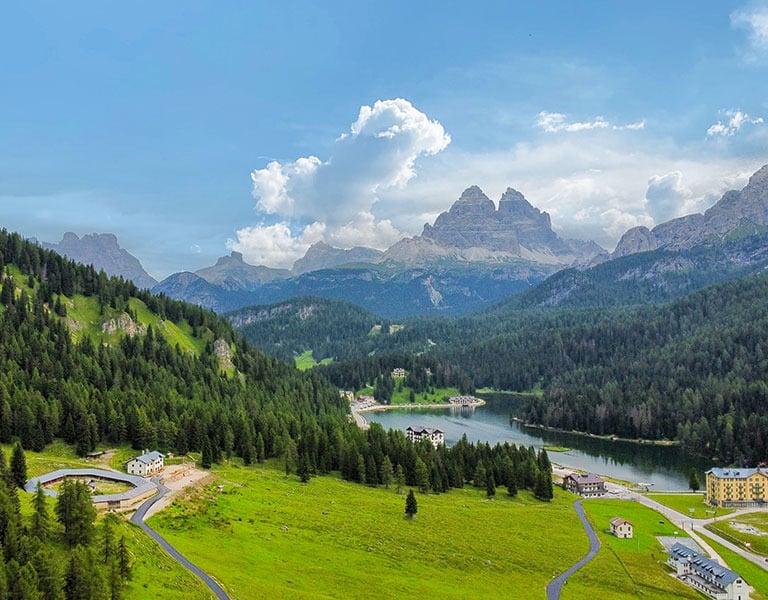 a scenic view of a mountain range with a lake misurina and mountains in the background