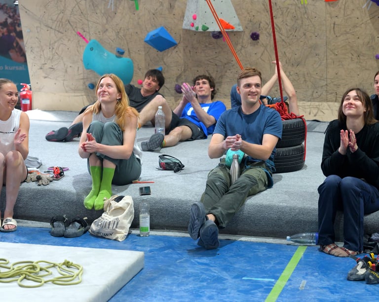 a group of people sitting on a bouldering mat