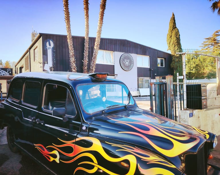 Taxi anglais noir avec flaming personnalisé stationné devant la façade de L'Entrepotes Conceptstore.