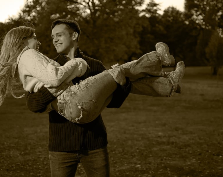 a man carrying a woman on his arms in a park